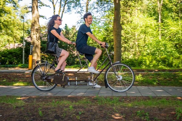 Mädchen und Junge radeln auf einem Tandem durch die Gemeinde Weert