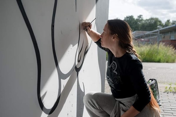 Woman is creating a mural on the Hall of Fame in Weert